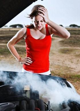 Woman Standing Over Smoking Automobile